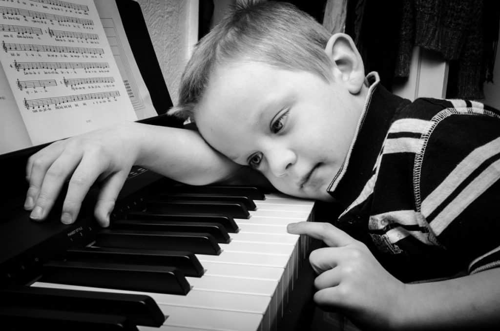 Child Laying Head On Piano